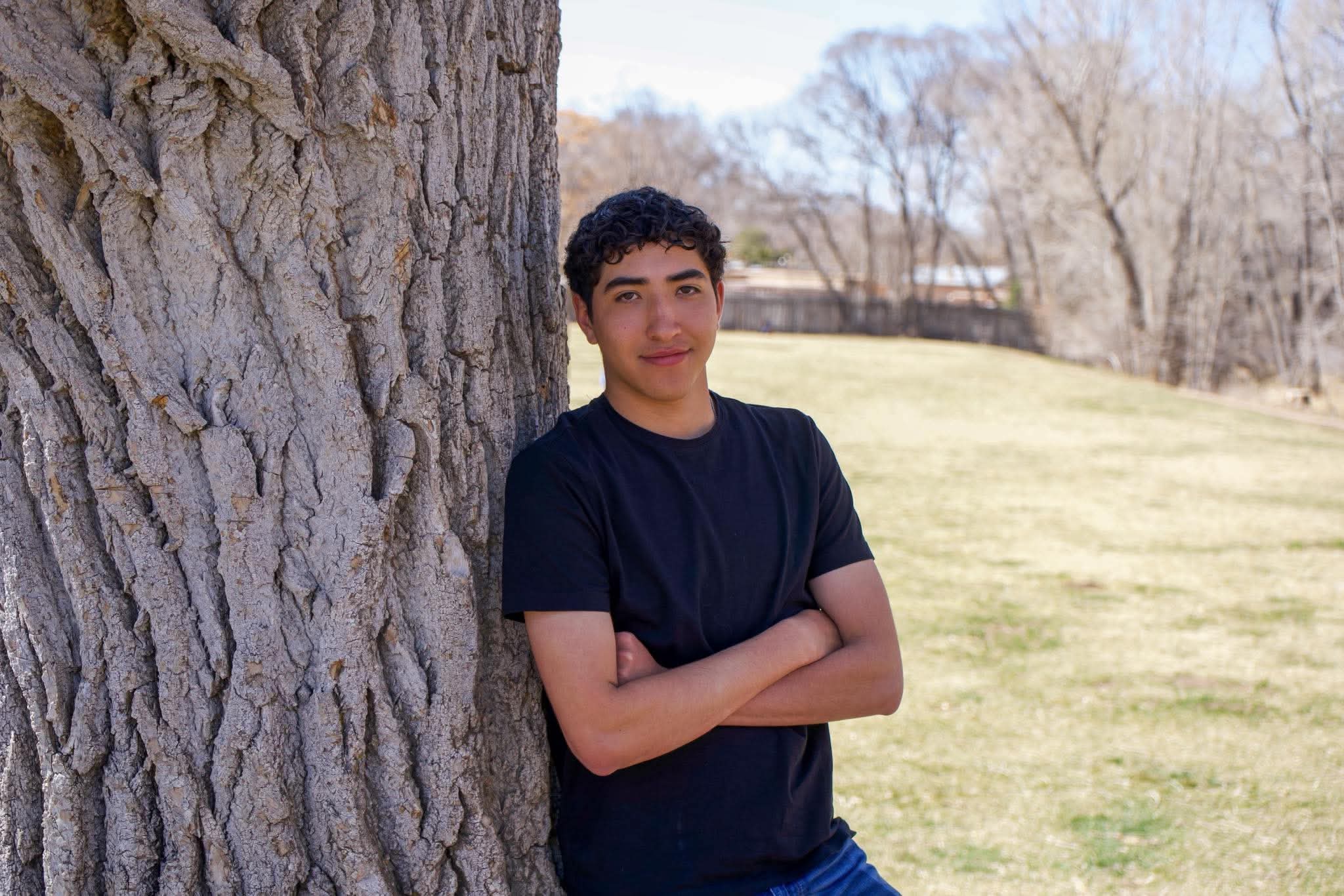 Senior portrait leaning against a cottonwood tree