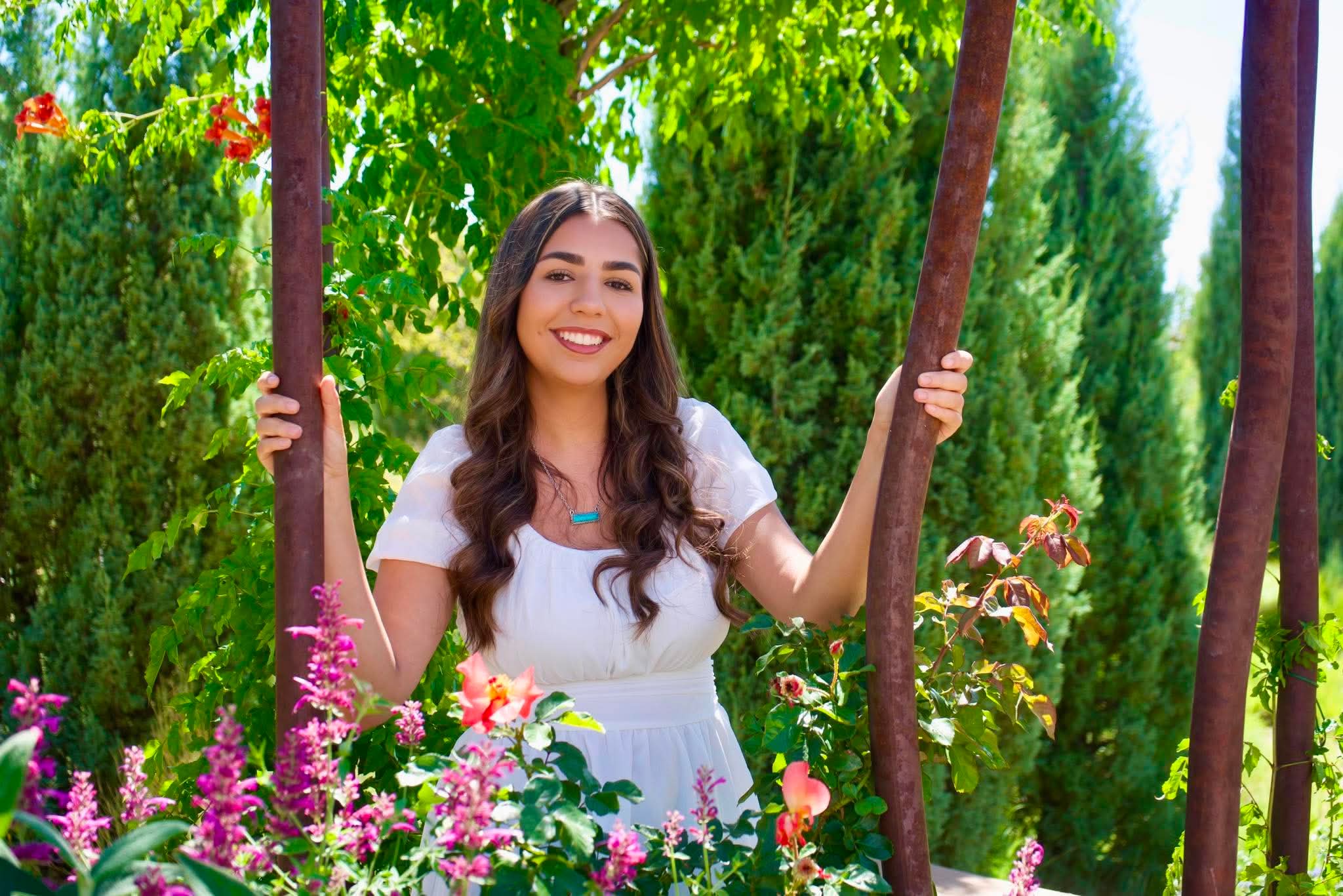 Senior portrait in a garden among roses