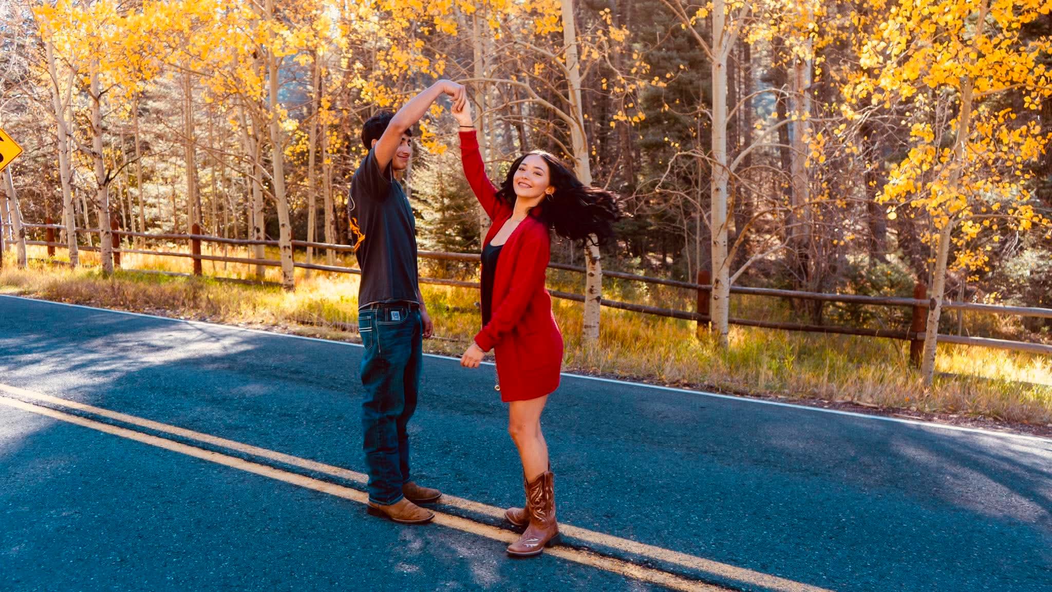 A couple dancing on a mountain road in fall aspens