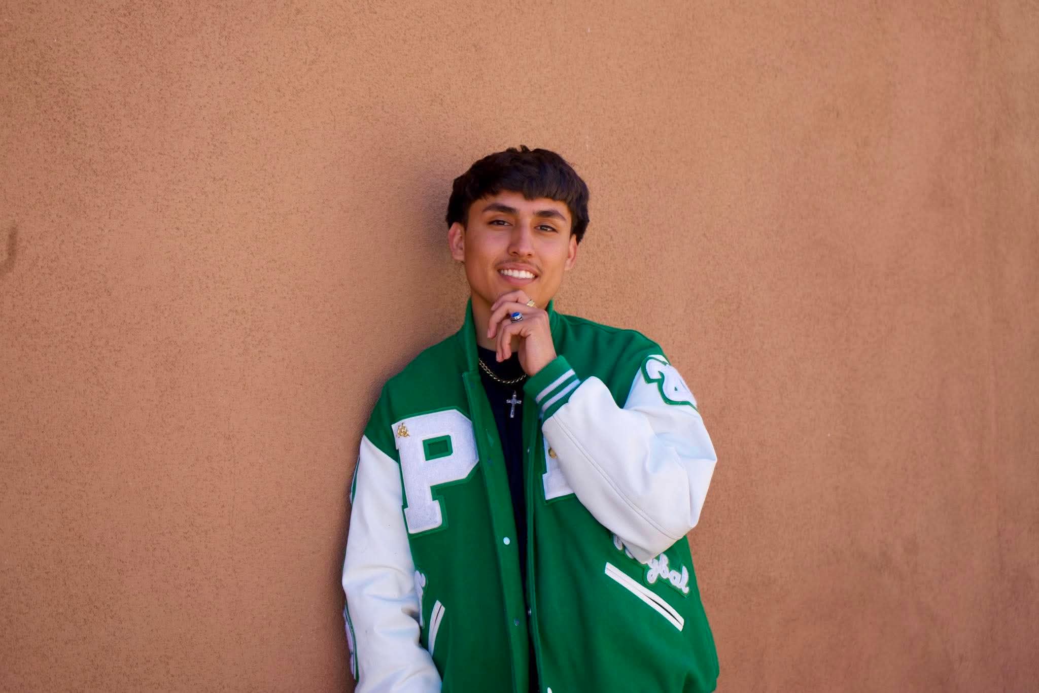 Senior portrait in a green letterman jacket