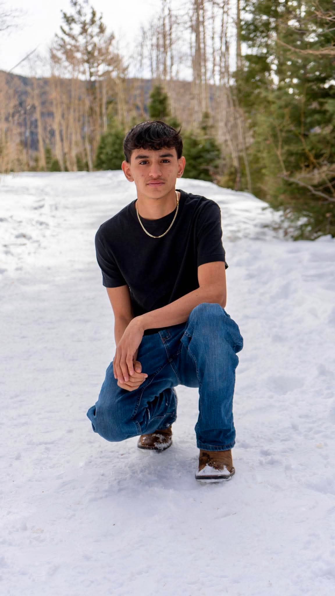 Senior portrait crouching in the snow