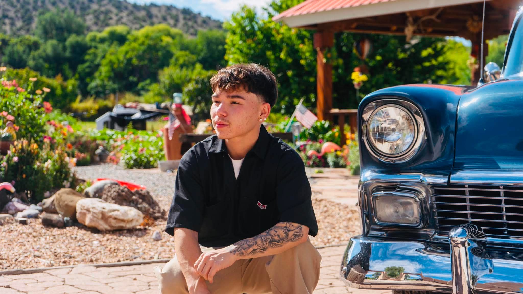 Senior portrait beside a second vintage car