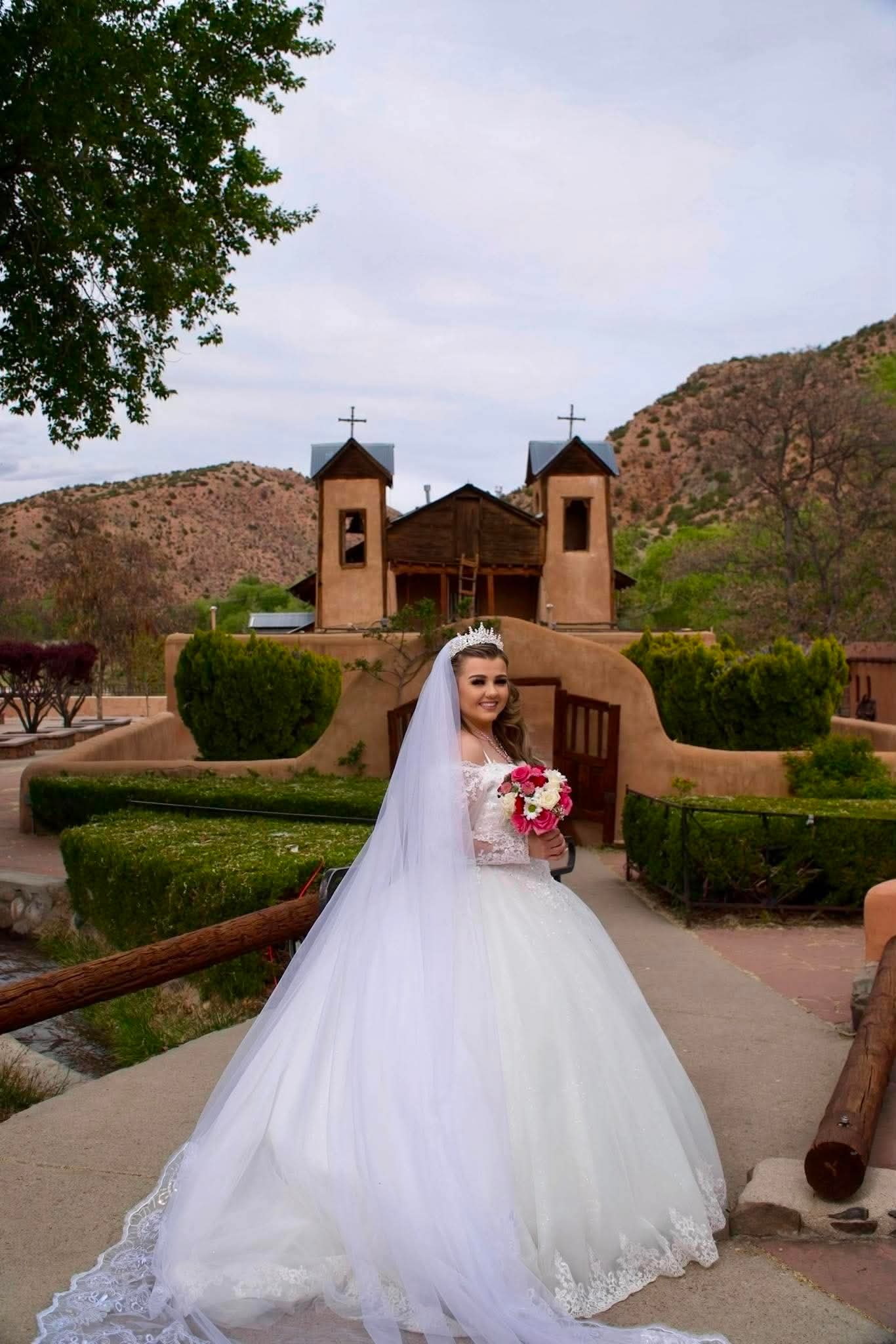 Bride in a ball gown and veil under a stone archway